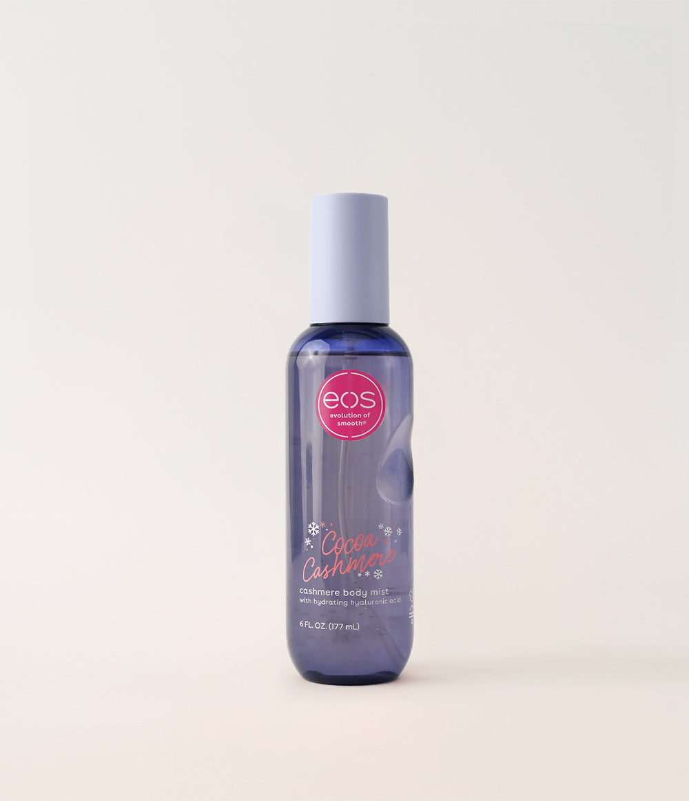 EOS body mist bottle with pink label on a light beige background